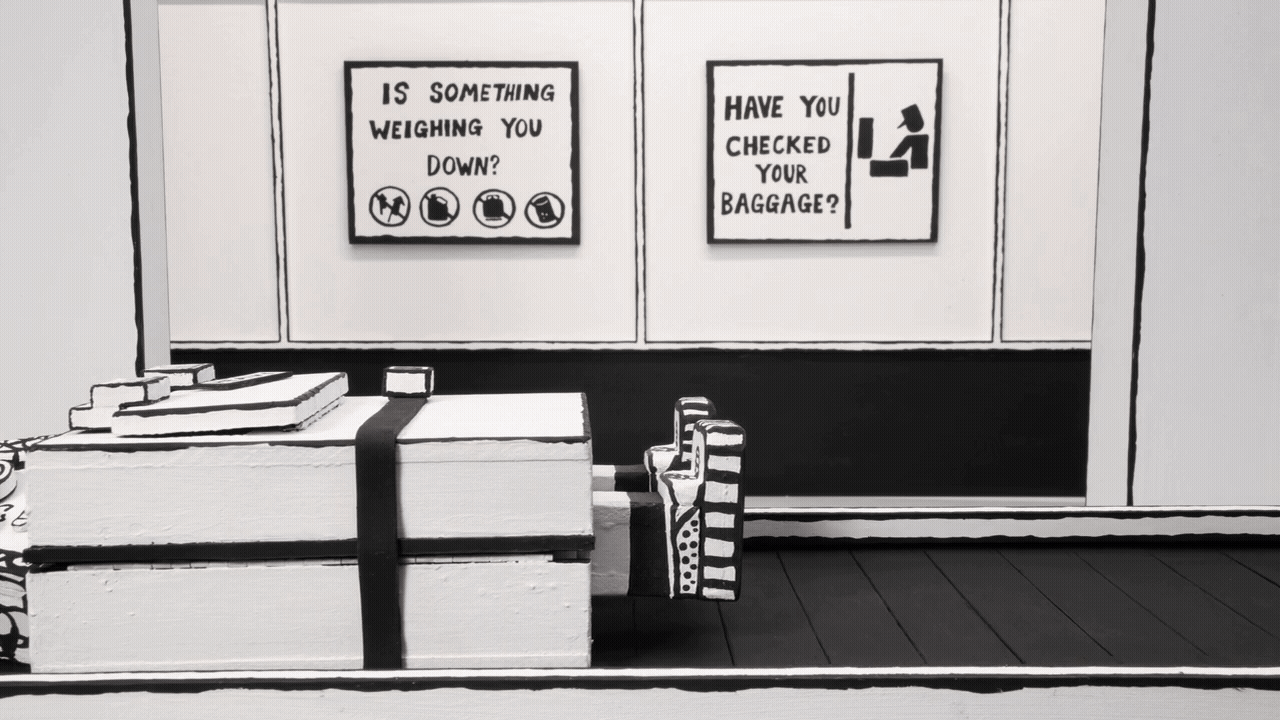 a gif from a black-and-white stop-motion animation of an anthropomorphized suitcase traveling along a conveyor belt