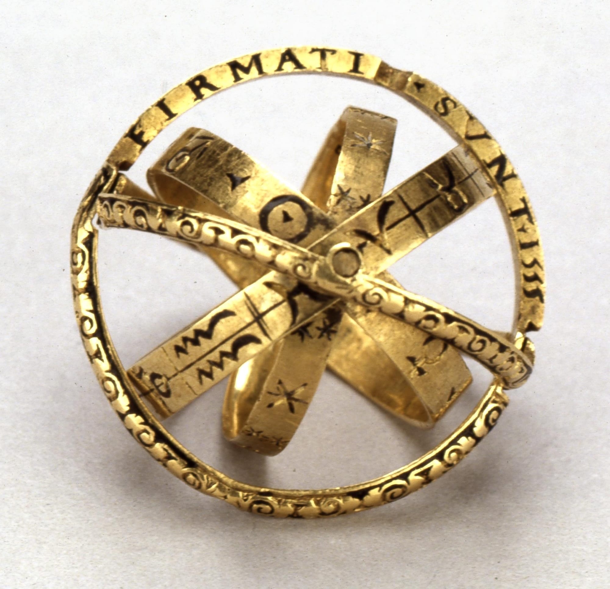 a photo of an armillary ring with engraved symbols and Zodiac signs