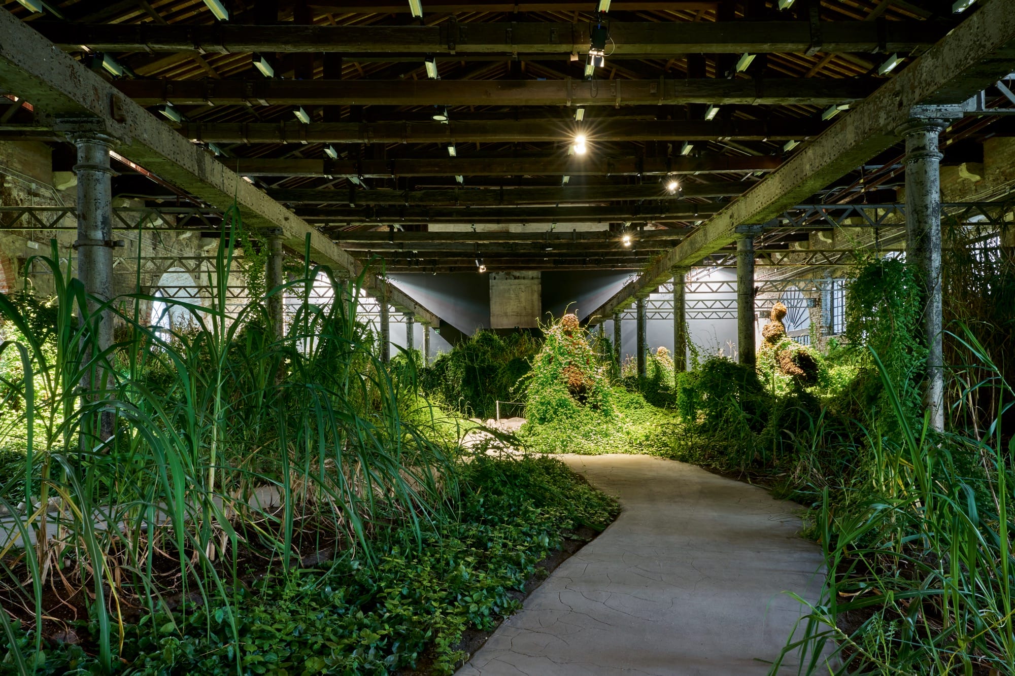an installation view of an artwork with a path through green mounds