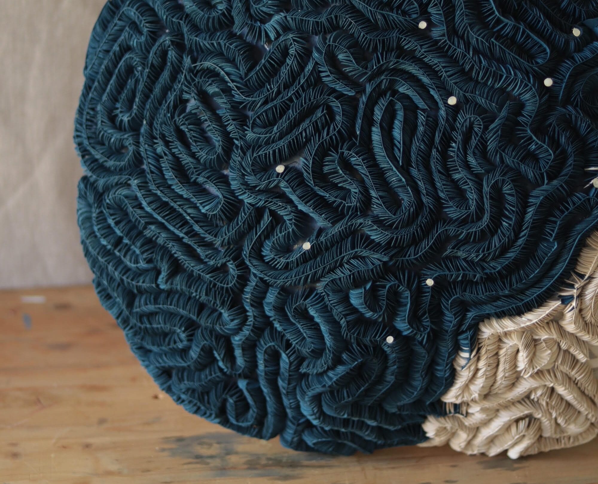 a detail of a sculpture made of tightly meandering textile, resembling coral