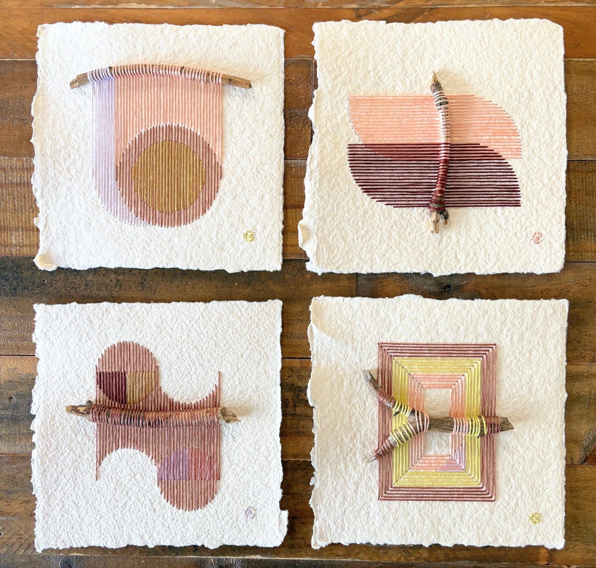 four paper artworks by Natalie Ciccoricco featuring handmade paper and thread wound around found twigs