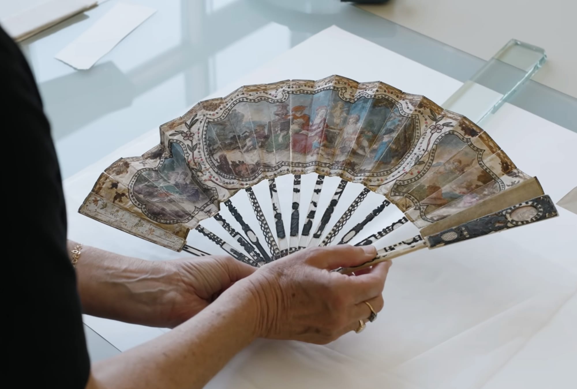 a white woman holding an 18th century fan