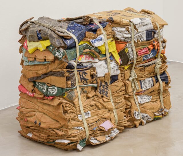 a sculpture by Ninon Hivert made of clay and other materials that mimics two compressed stacks of cardboard boxes