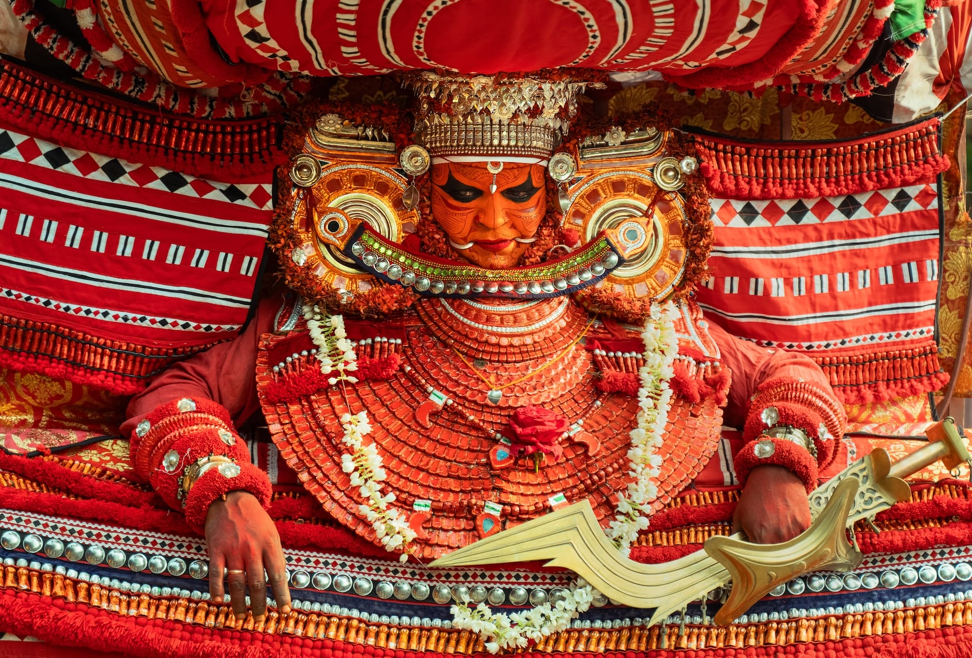 a photograph by Navneet Jayakumar of an elaborate ceremonial outfit worn by a performer for Theyyam, in Kerala, India