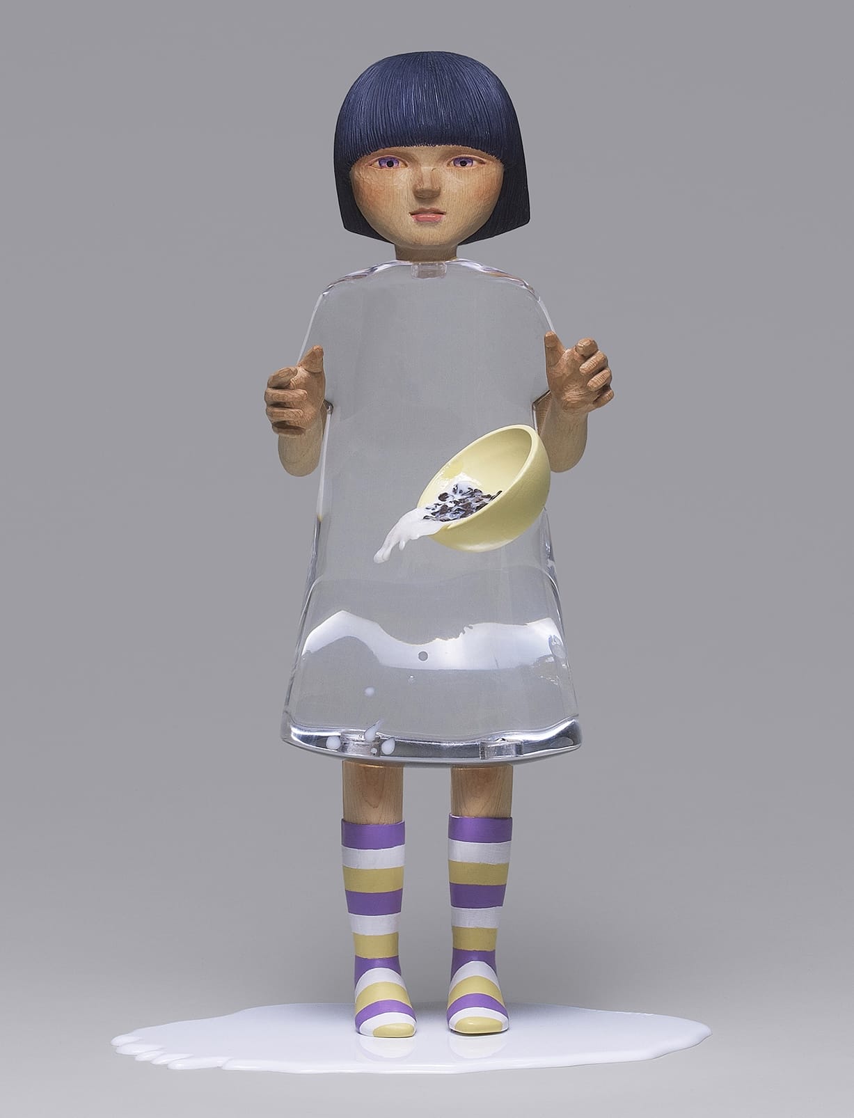 two views of a sculpture by Ayako Kita of a young woman with a carved wood head and clear resin dress