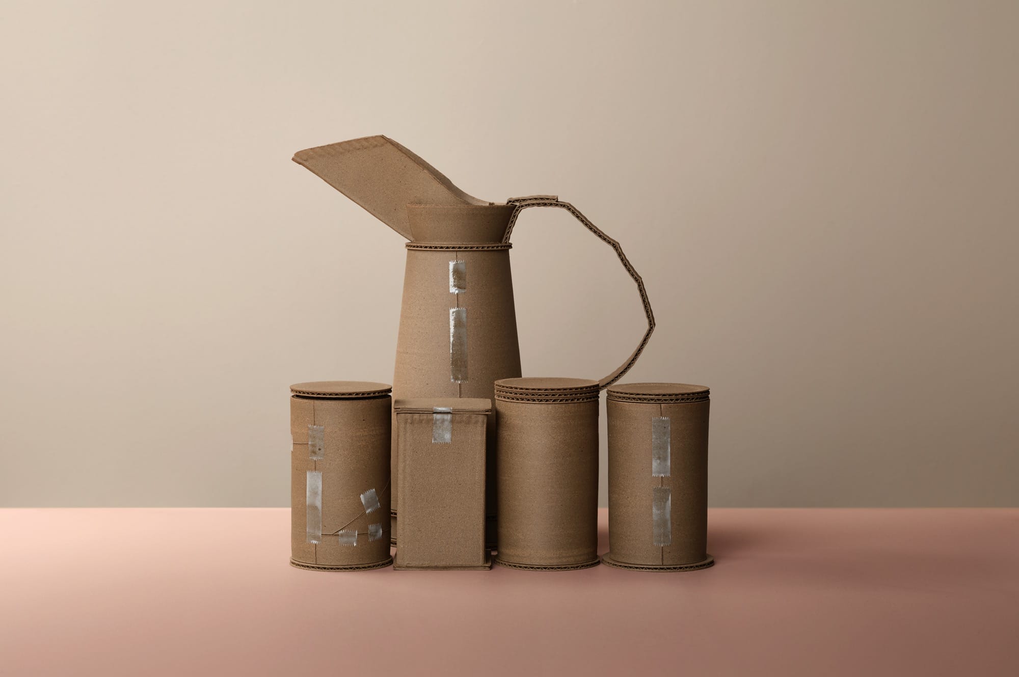 a series of ceramic vessels by Jacques Monneraud that resemble cardboard with tape, arranged to mimic a painting by Giorgio Morandi