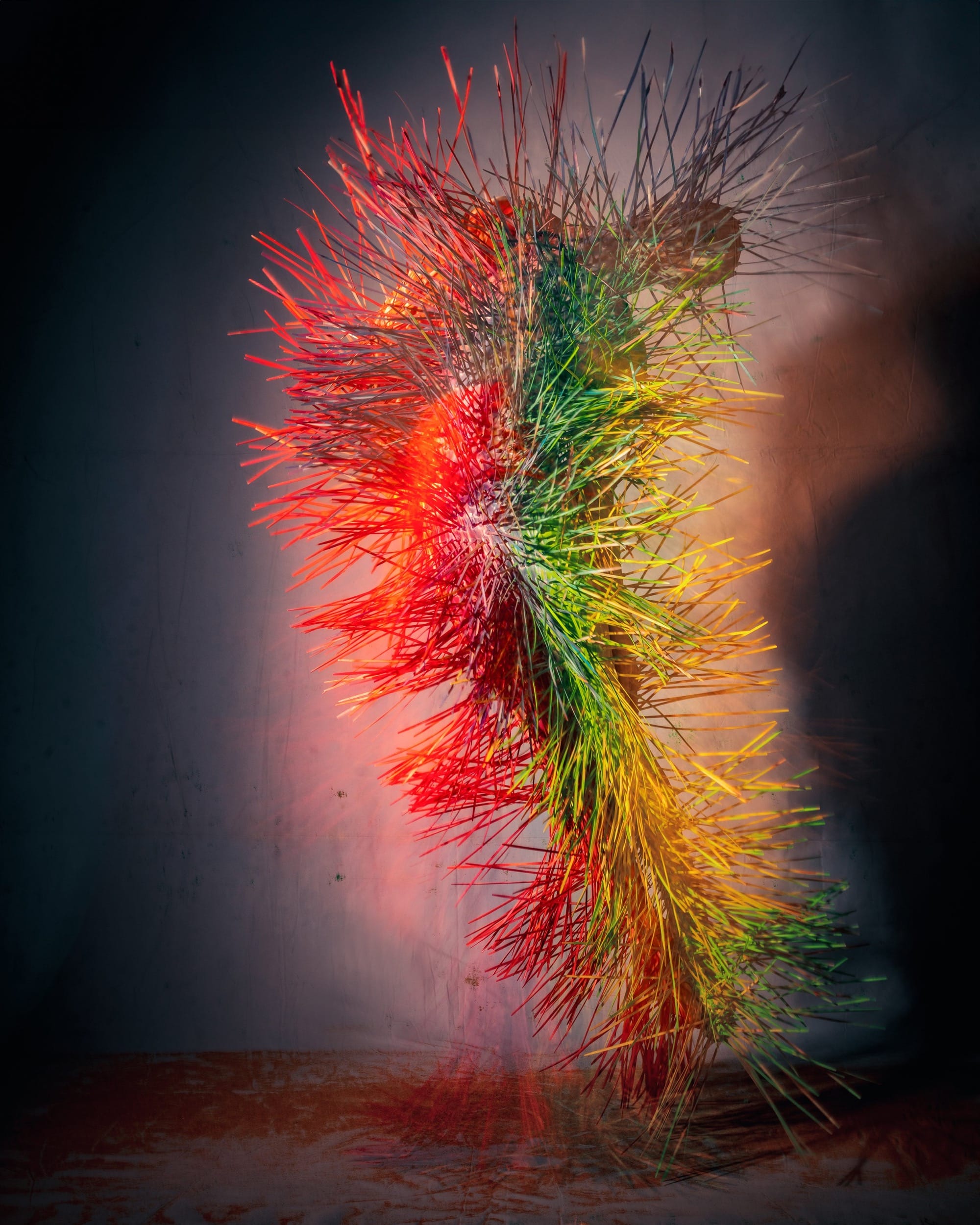 a costumed figure with an all-over outfit of colorful fabric strands that swing in motion