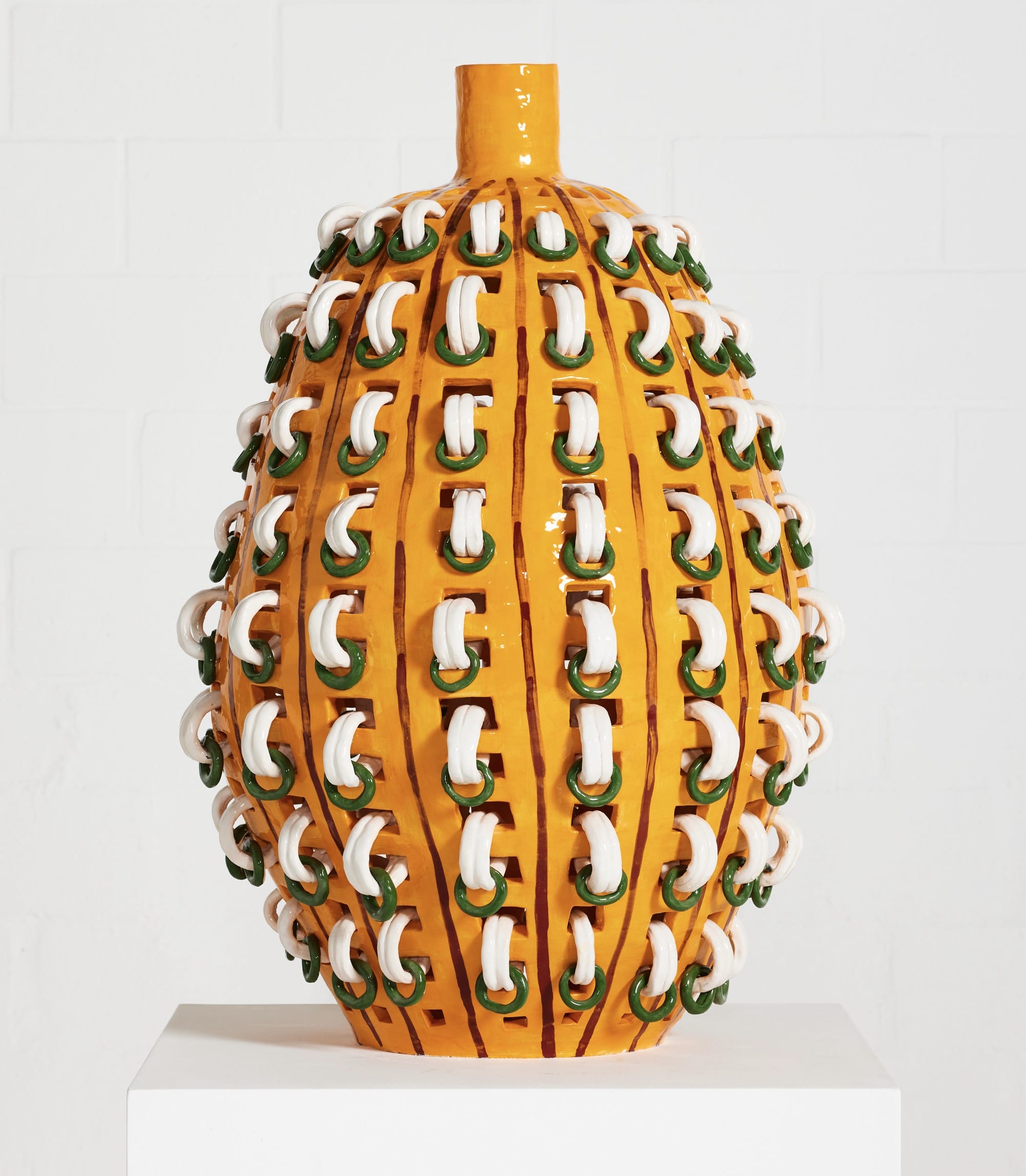 a bright yellow, large-scale ceramic vessel with white rings creating an overall pattern