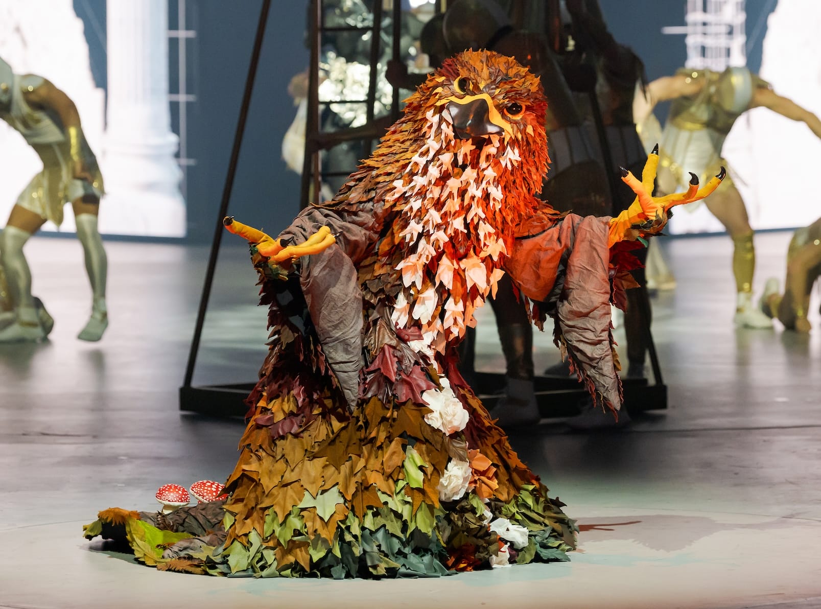 an elaborate costume of an eagle-like creature representing fall, worn by a performer on stage